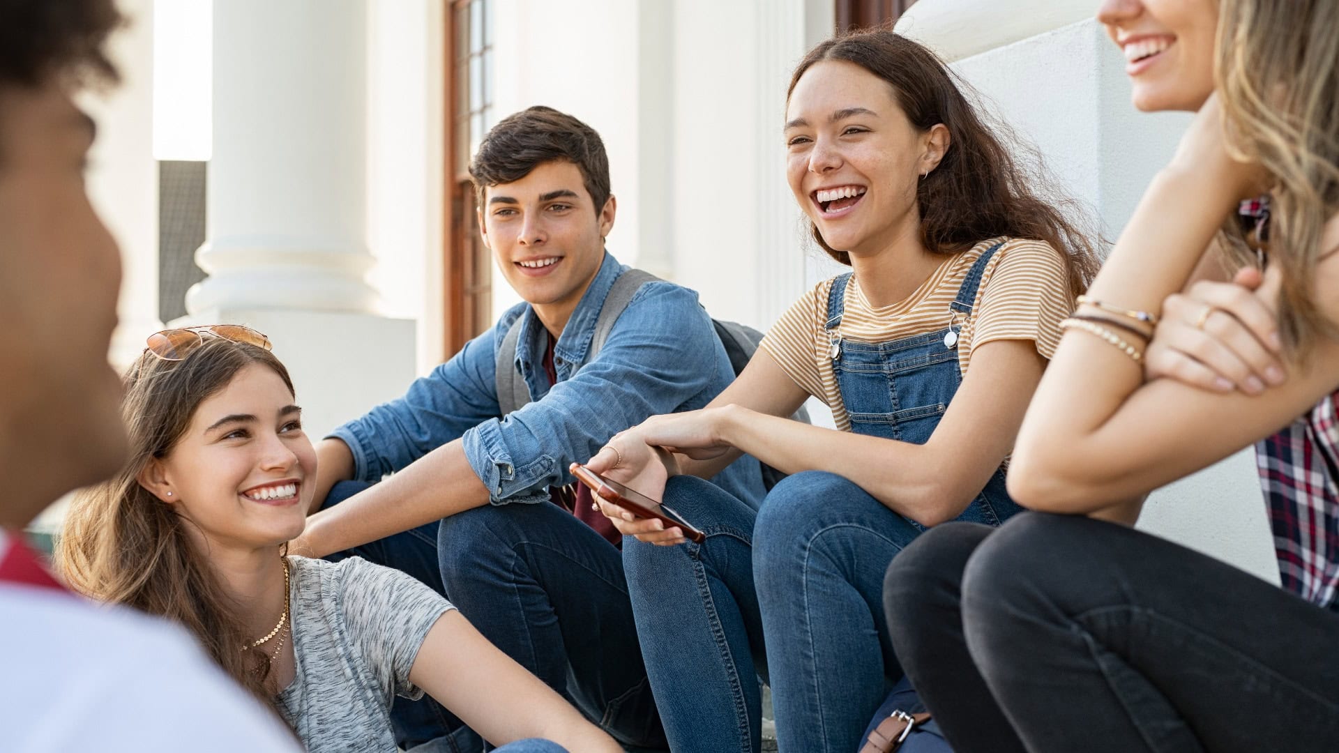 Freunde im Teenageralter sitzen zusammen und lachen